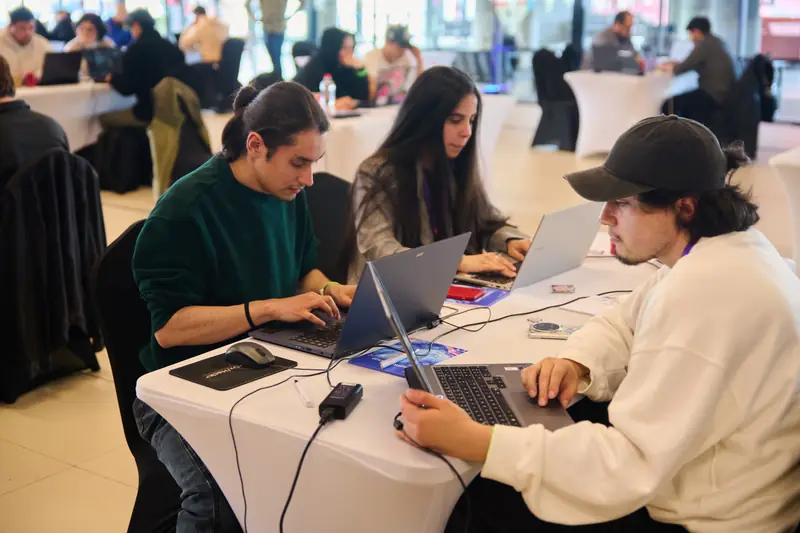 Tres integrantes del equipo ProGarLabs trabajan concentrados en sus computadores en una mesa del salón.